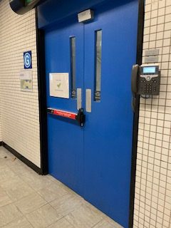 Blue double doors set in a tile wall with a landline phone