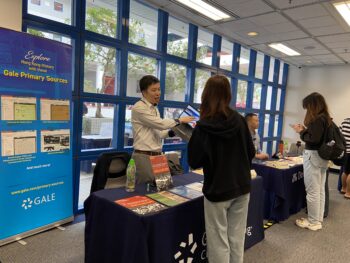 Image showing students approaching booths to learn about the database and get the stamp