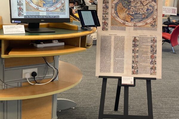 Computer monitor displaying project video and an easel showing the two sides of the 1493 map of the "Second Stage of the Wolrd" from the Nuremberg Chronicle