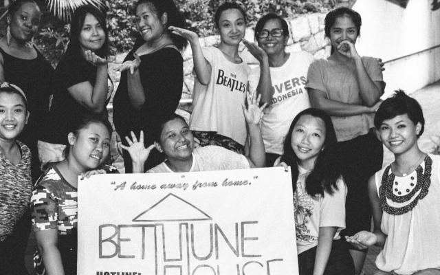 Group of eight women gathered around a sign that says Bethune House