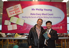 photo of Philip Yeung and another man standing in front of the Book Talk banner