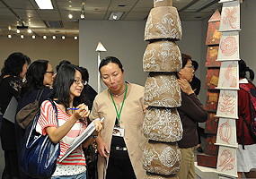 photo of 2 women near some of the "totem poles" from So-Lan's exhibition