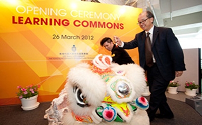 image of president dotting eye of lion at opening ceremony of learning commons